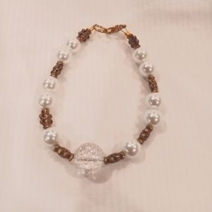 Homemade bracelet with gold lobster claw clasp. White beads & gold accent beads
